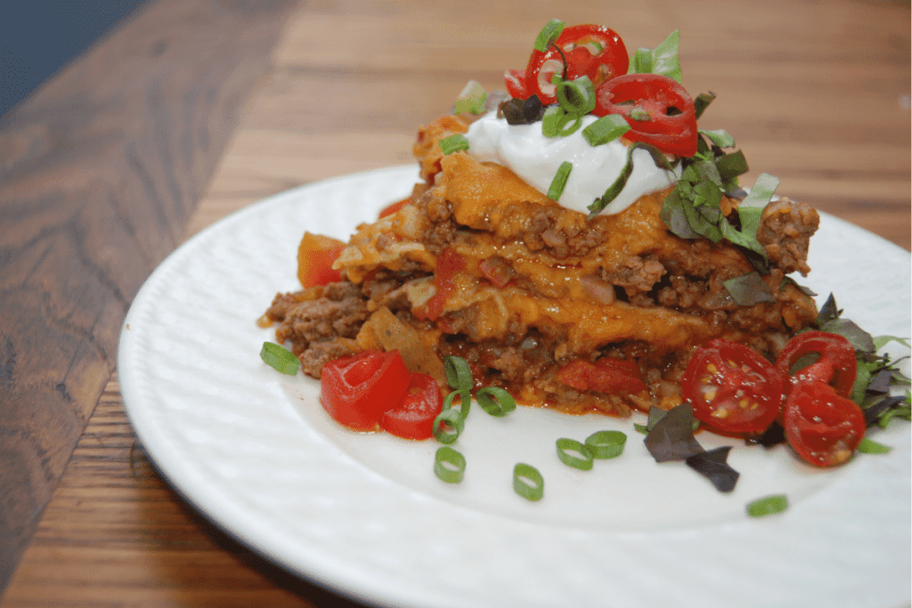 slice of easy taco casserole with radishes on a plate on a table 