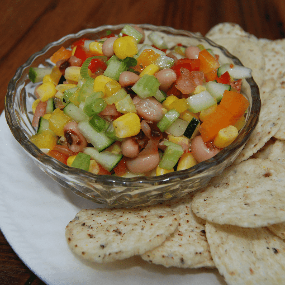 small bowl of fresh veggie salsa on a plate with tortilla chips