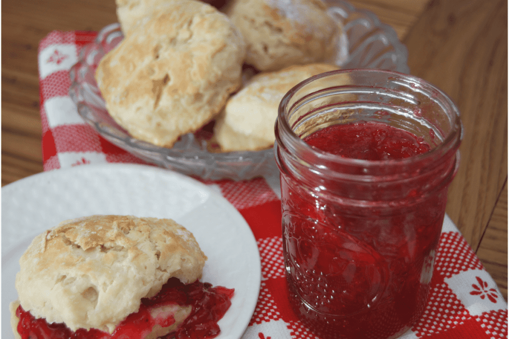 jar of strawberry jam with sure jell next to some biscuits